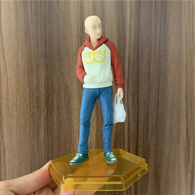 Figura One Punch Man de 18 cm | Figura de PVC de Saitama con una sudadera con capucha oppai, que captura un momento casual del héroe. Ideal para coleccionistas y fans de One Punch Man, así como como decoración o regalo.