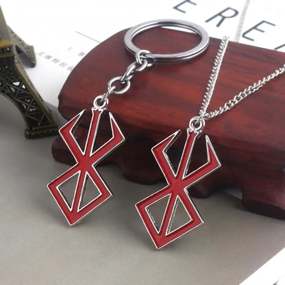 Colgante y llavero de metal con esmalte rojo que representa el icónico símbolo de Berserk. Estas piezas de joyería son perfectas para los fanáticos del anime y el manga, ideales para agregar un toque de estilo vikingo a tus accesorios cotidianos.