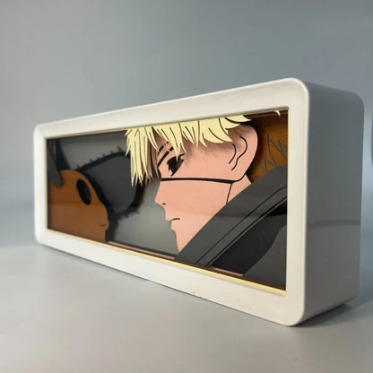 Lampe Décorative Chainsaw Man | Boîte lumineuse avec design en papier découpé représentant le visage de Denji et Pochita. Parfaite pour décorer une chambre ou un bureau, cette lampe offre une ambiance unique pour les fans de manga et d'anime