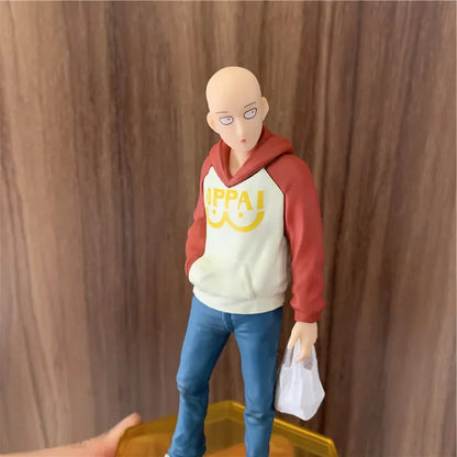 Figura One Punch Man de 18 cm | Figura de PVC de Saitama con una sudadera con capucha oppai, que captura un momento casual del héroe. Ideal para coleccionistas y fans de One Punch Man, así como como decoración o regalo.