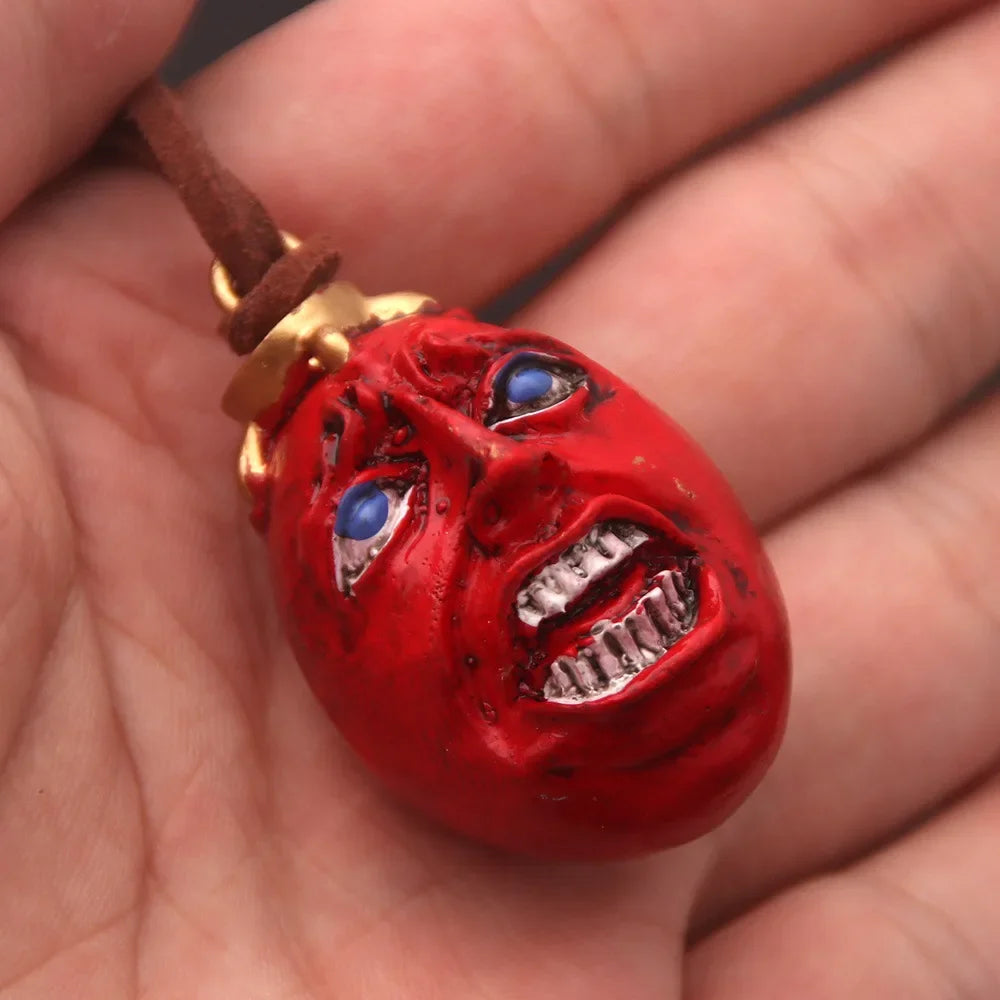 Pendentif et porte-clés représentant le Behelit, œuf du Roi de Berserk. Ces bijoux sont parfaits pour les fans de l'anime et du manga, idéals pour ajouter une touche de style gothique à vos accessoires quotidiens